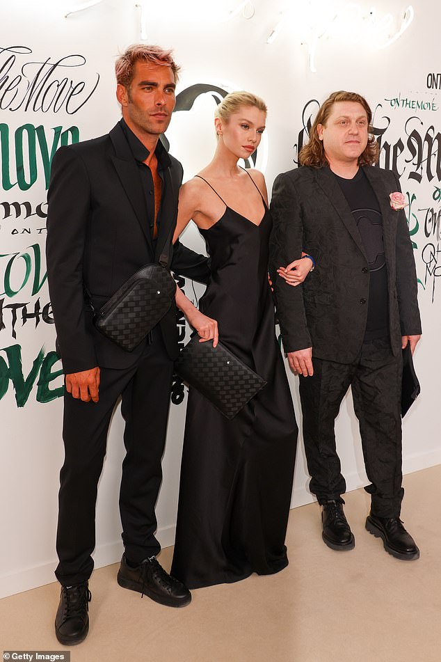 Glamour: Stella added to her outfit with a matching clutch bag while her tresses were styled into a sleek updo (pictured with John Kortajanera and Marco Tomassetta)