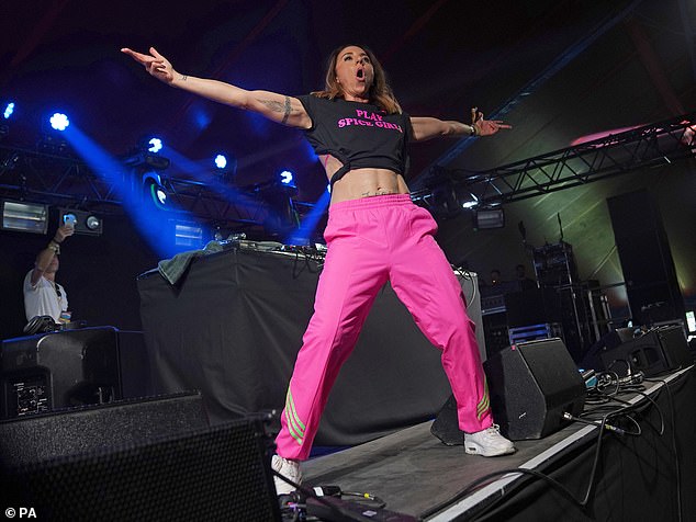 Performance: She completed her look with a pair of bright pink Adidas trousers and comfortable white trainers as she bounded around the stage