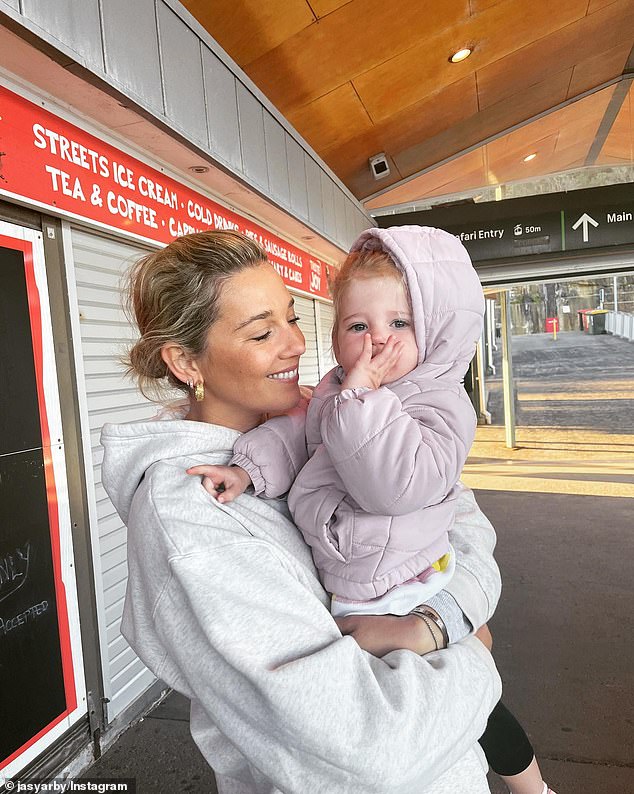 Happy times: Jasmine nestled into a rugged up Harper before the boat ride on the harbour earlier this month