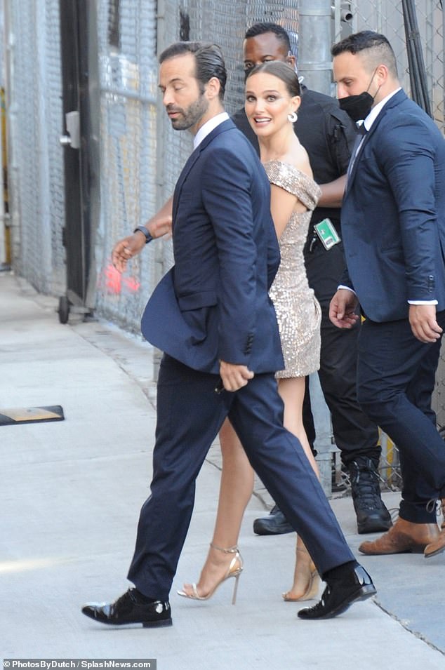 Cute: Natalie peeked back at photographers while flanked by her bodyguards