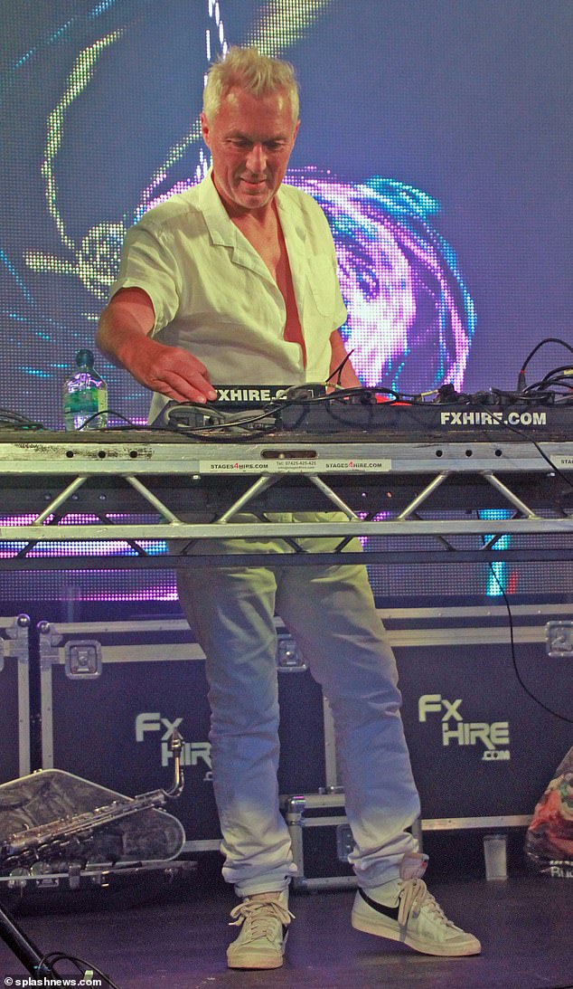 Stylish: He channeled Ibiza DJ vibes as he paired a white linen shirt with some matching jeans and Nike trainers while he entertained the crowds