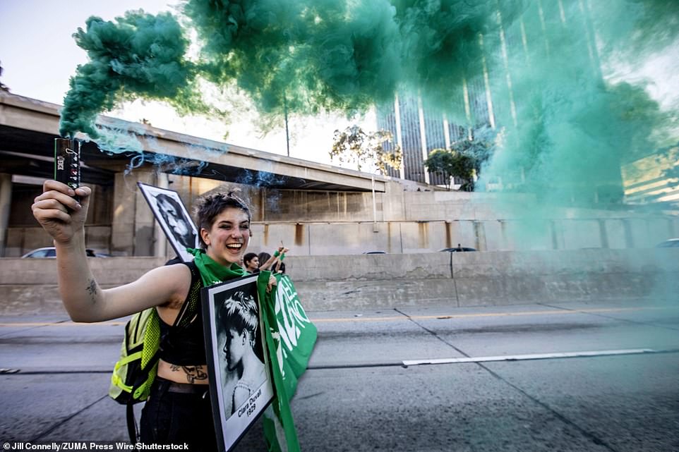 One activist sets off a smoke flare amid abortion rights protest on the 110 Freeway in Downtown Los Angeles