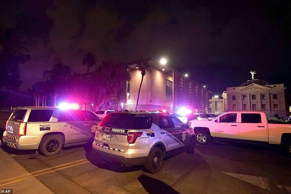 With tear gas in the air, a large number of police surround the Arizona Capitol after protesters reached the front of the AZ Senate building after the Supreme Court overturned the landmark Roe v. Wade abortion decision Friday