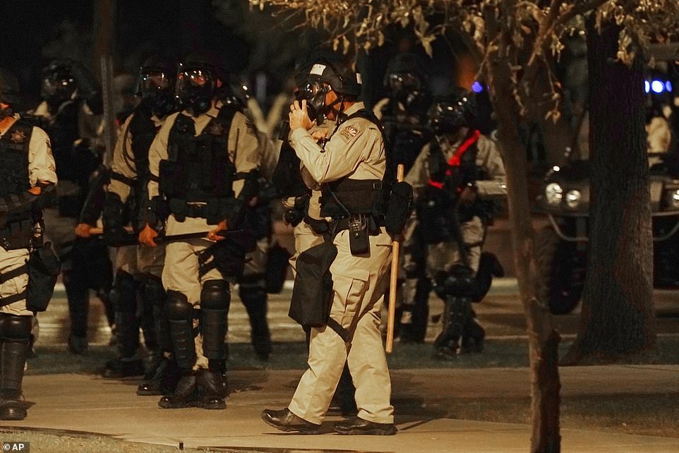 Riot police surround the Arizona Capitol after protesters reached the front of the Arizona Sentate building