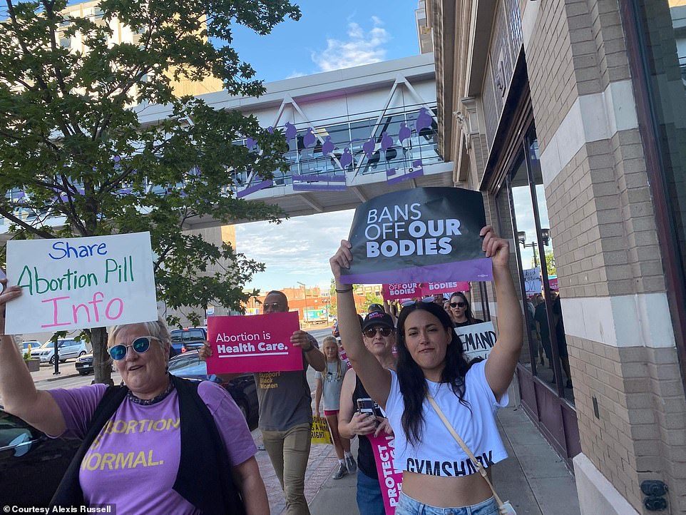 Russell is seen marching through Cedar Rapids on Friday with her fellow protesters, shortly before the crowd was rammed by the pickup truck