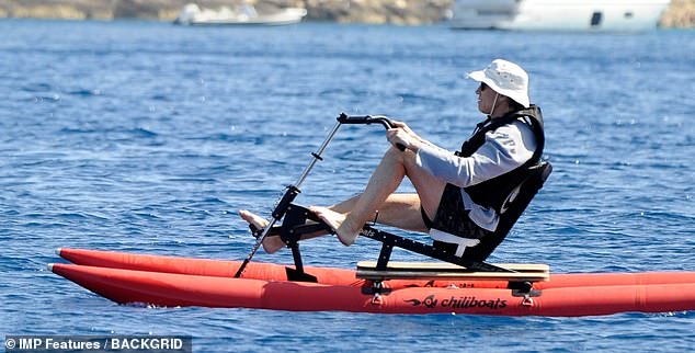 Skilled: He donned a white hat and a black life jacket for safety as he deftly steered the water bike around