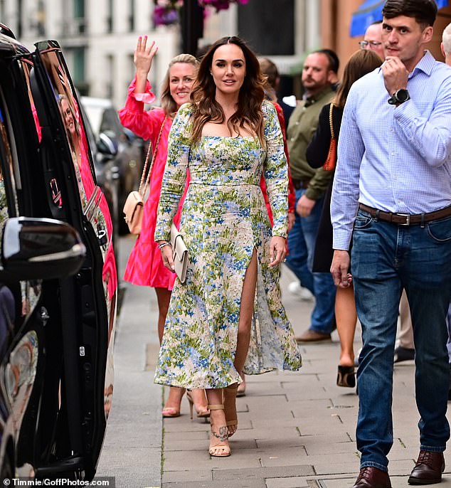 Outfit: Letting her brunette locks fall loose down her shoulders, the socialite added to her outfit with a cream clutch bag