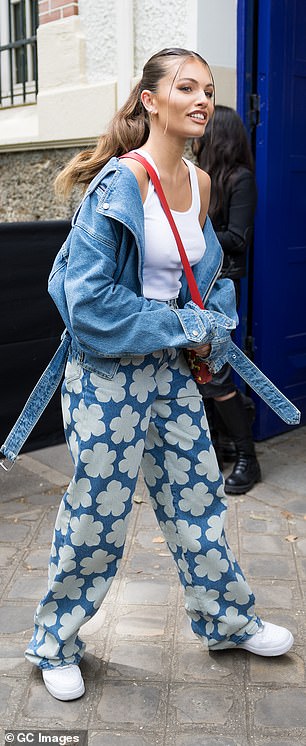 Details: The stunner added a pop of colour with a scarlet cross-body bag, finishing the look off with some white chunky trainers