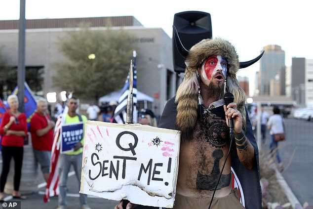 Jacob Anthony Chansley, who also goes by the name Jake Angeli, a QAnon believer known as the 'QAnon Shaman,' speaks to a crowd of Trump supporters in November 2020