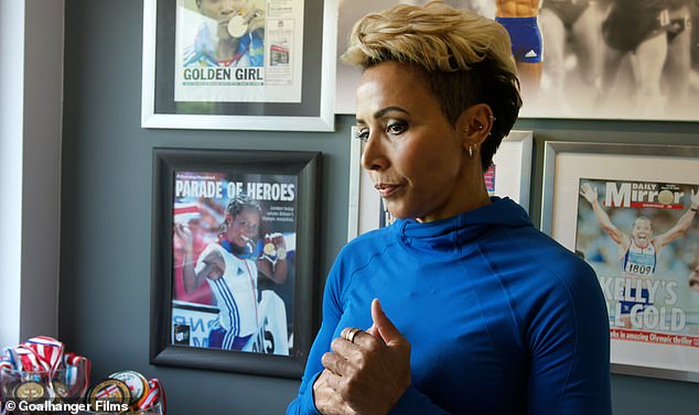 Tough: One scene shows Kelly in a room decorated with her winning newspaper articles, medals and successes - as she solemnly stands in front of the collection