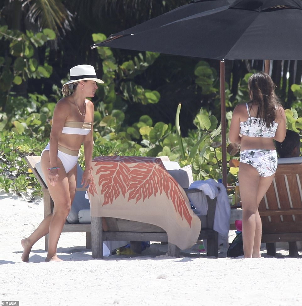 Having fun: In addition to enjoying lunch under some black umbrellas, a waiter was seen pouring her a flute of champagne as she kept a watchful eye on her stepdaughter Isabella, 12