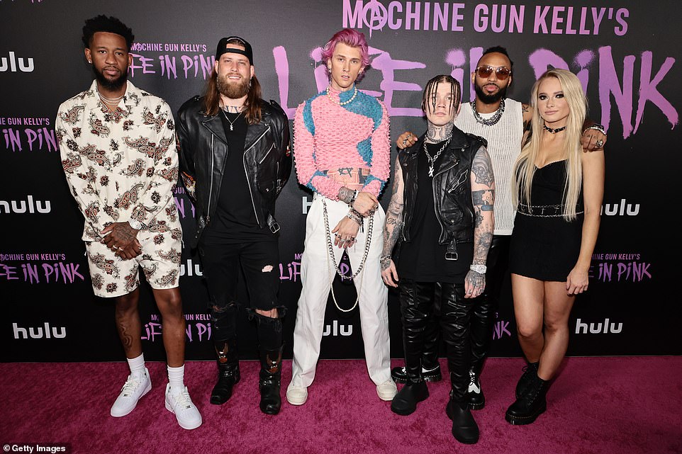 All together: The rocker posed with his band, including Steve 'Baze' Basil (second from left) who plays bass/keyboards, and was clad in all black