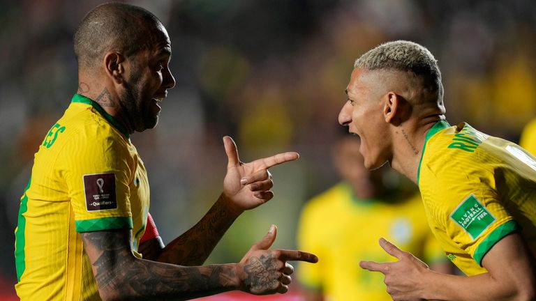 Richarlison celebrates with team-mate Dani Alves after scoring Brazil&#39;s fourth goal against Bolivia 