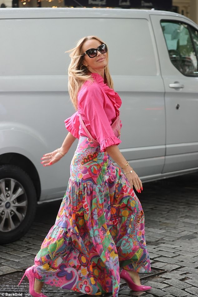 Turning heads: The TV and radio star, 51, wowed in a bold pink ensemble as she left the London studios after another morning on air