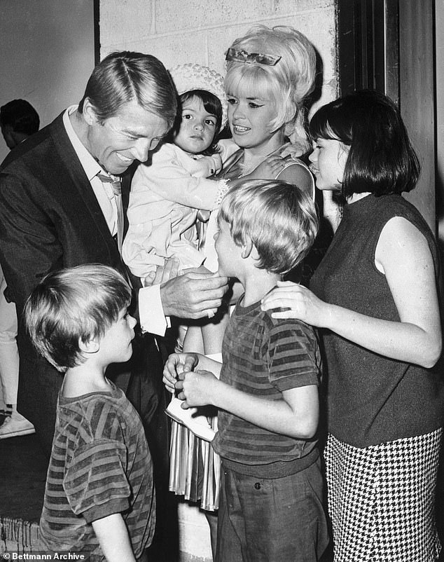 Memories: Hargitay being held by her mother in 1996, with her father Mickey Harigtay, brothers Zoltan and Mikos, and her mother's daughter Jayne Maria, from a previous marriage