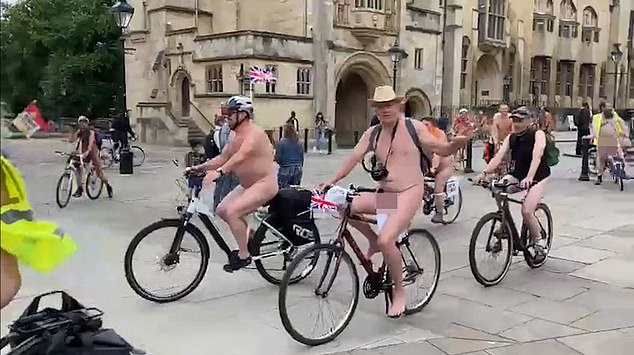 Diverting attention? Smiling NAKED cyclists in Bristol are met with roars as they pass by protests