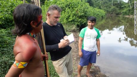 Dom Phillips (C) talks to two indigenous men in Aldeia Maloca Papiú, Roraima State, Brazil in 2019. 