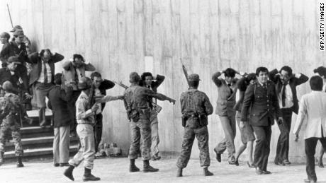 Colombian military protect a group of magistrates leaving the Palace of Justice in Bogota on November 6, 1985. 