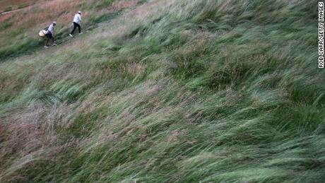 Scheffler and caddie Ted Scott brave the wind.