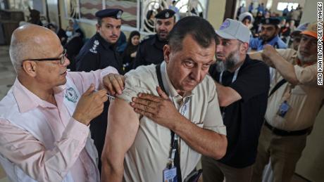 A Palestinian Muslim pilgrim gets a dose of a vaccine against Covid-19 at the Rafah border crossing with Egypt on June 21, as he heads to Saudi Arabia for the annual Hajj pilgrimage.