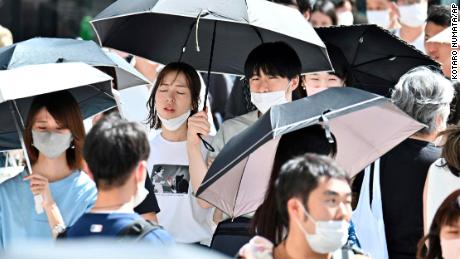 People wearing face masks are seen at Ginza district in Tokyo on June 26, 2022. 