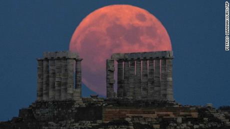 A strawberry full moon rises behind the Temple of Poseidon at Cape Sounion, Greece, in June 2021.