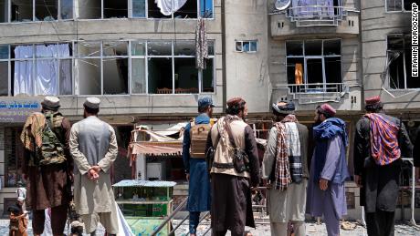 Taliban fighters gather at the site of an explosion in front of a Sikh temple in Kabul on Saturday. 