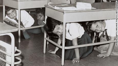 Students at a Brooklyn middle school &#39;duck and cover&#39; during a practice drill for a nuclear attack in 1962.