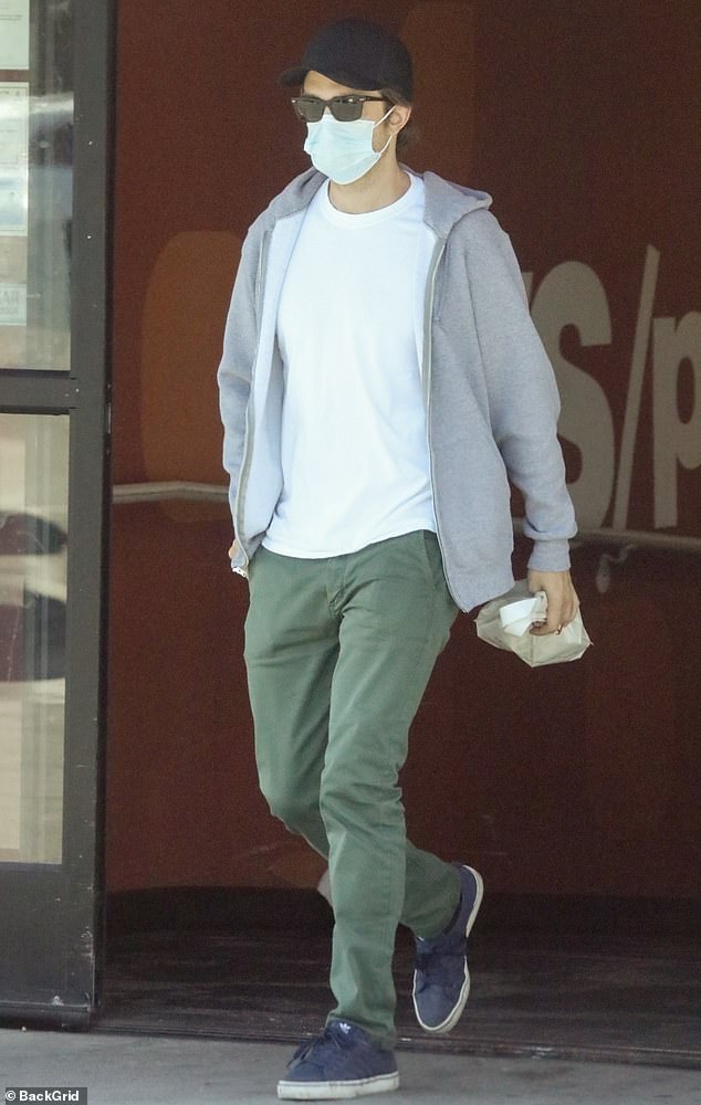 Robert Pattinson cuts a casual figure in olive trousers and hoodie as he steps out to run errands