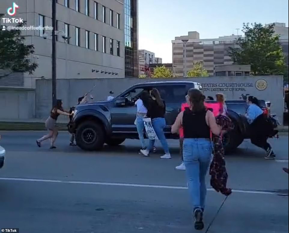 Two people appeared to be in front of the black pickup as it continued driving through the crowd, despite screams. One of the women, in the white t-shirt and jeans, told DailyMail.com about wrestling with the driver and yelling at him to stop