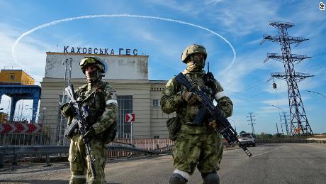 Russian troops guard an entrance of the Kakhovka power plant on the Dnieper River in southern Ukraine on May 20, 2022.