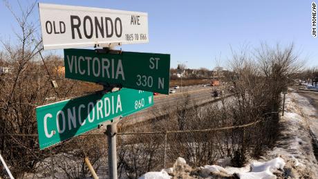 This 2010 photo shows a sign for &quot;Old Rondo Ave.: 1865-1966&quot; standing atop other street signs overlooking Interstate 94, left, and a frontage road in St. Paul, Minn., where homes, stores and other businesses once stood. (AP Photo/Jim Mone)