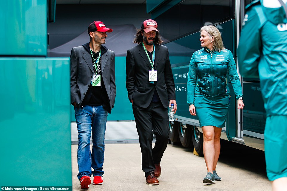 Keanu was trying to keep a low profile in a battered old red cap against a smart black suit over a casual black v-neck t-shirt