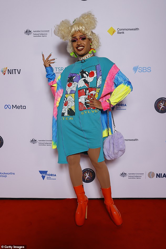 Drag queen Cerulean (pictured) chose an 1980s inspired look with a tie-dyed cartoon character shirt dress and towering orange go-go boots