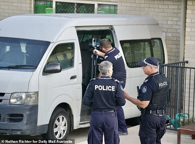 A child's booster seat was visible as officers took pictures from multiple angles, jotted down notes and discussed their findings