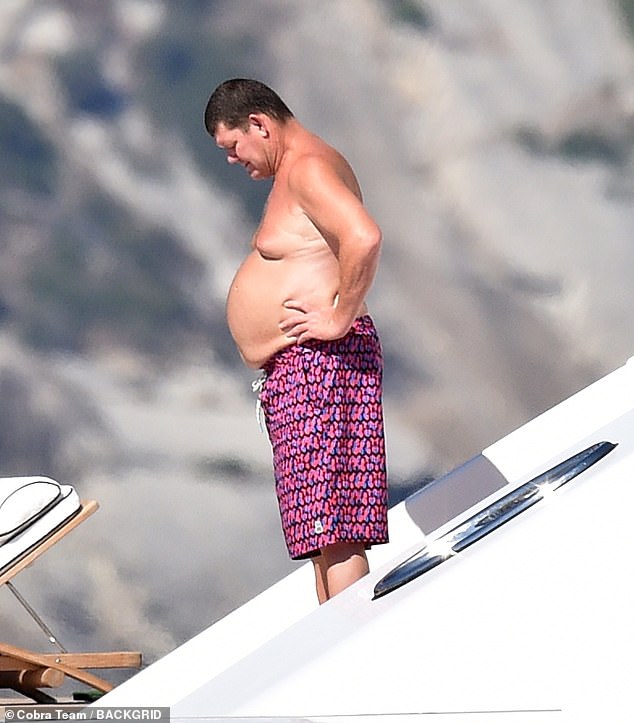 Packer appeared relaxed in the new photographs, going shirtless and taking a dip in a pair of colourful boardshorts