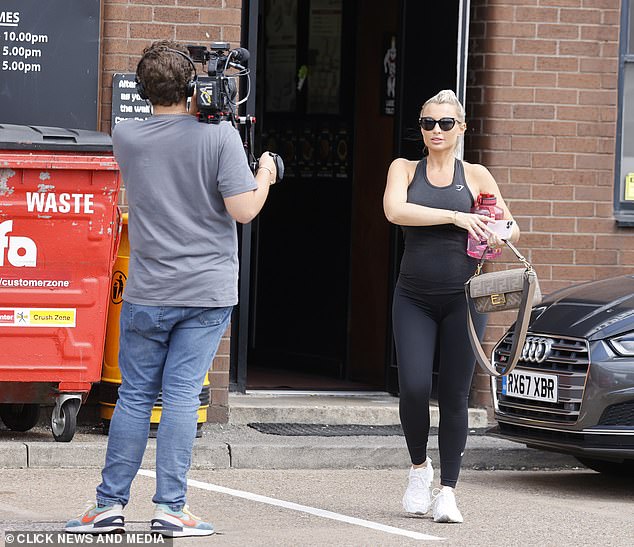 Stylish: The mother-of-two sported a pair of black shades and carried a beige Fendi handbag in one hand and a pink water bottle in the other