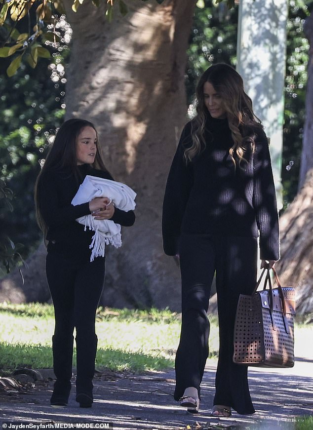 The pair carried various items into the park for their picnic, including a white blanket and a tote bag full of snacks