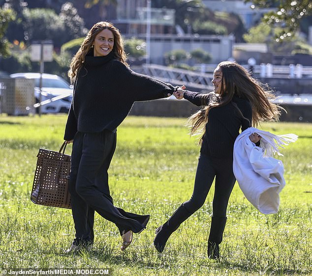 The Neighbours star beamed as she and Aleeia, eight, made their way to an idyllic patch of grass to set up a picnic