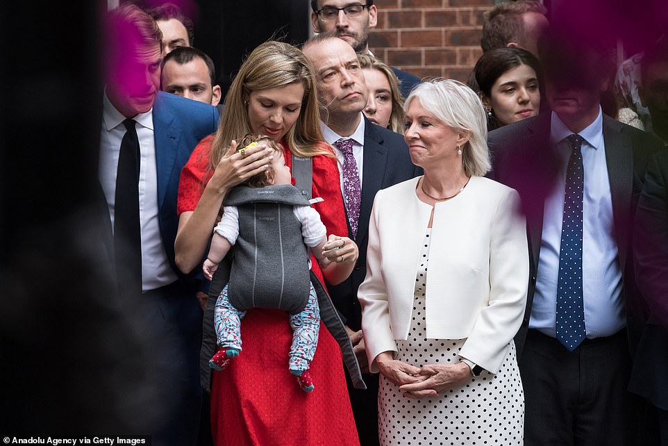 Carrie Johnson and her daughter Romy alongside Culture Secretary Nadine Dorries as Mr Johnson announced his resignation on Thursday