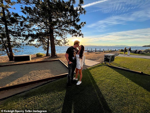 Romantic: In another image, the lovebirds were seen kissing as they stood on a lawn while the sun set over the lake in the background