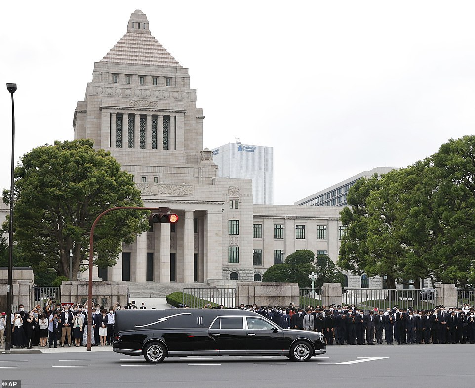 Abe's hearse passes in front of the National Diet Building - home of the Japanese parliament - as lawmakers gather outside to pay their last respect to a man who led the country longer than any other elected ruler