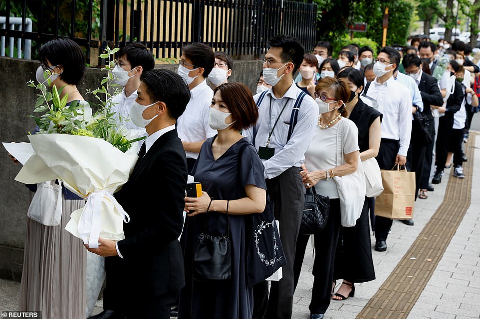 People line up to offer flowers for Mr Abe at the Headquarters of the Japanese Liberal Democratic Party in Tokyo