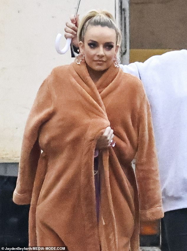 Former Bachelor star Abbie Chatfield, 27, kept warm on set with a fluffy beige robe around her shoulders