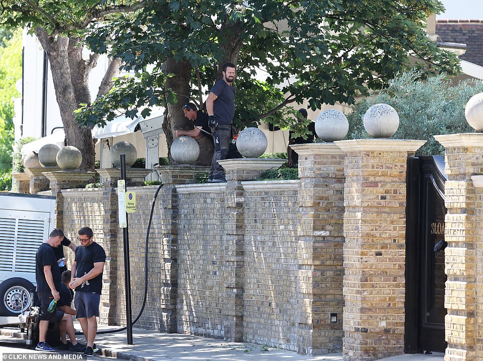 Hard at work: Workers were also seen standing on top of the exterior wall to get the final details ready