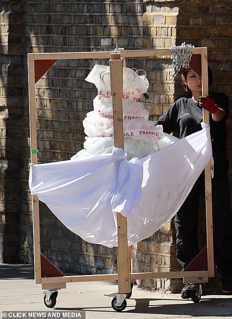 Lavish do: A staff member wheeled a frame covered with bubble wrap, a sheet and 'fragile' tape inside