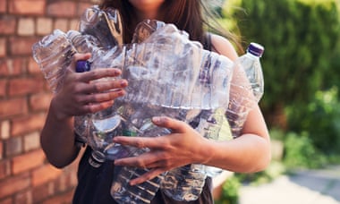 Young woman recycling plastic bottles