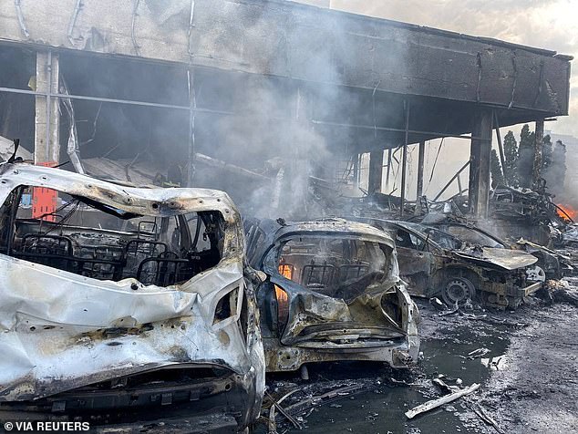 Cars smoulder in front of an office block in the city of Vinnytsya, western Ukraine, after it was struck by three Russian missiles that landed around 10.50am on Thursday