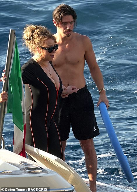 Cute couple: Mariah held onto Bryan's hand as he strolled about shirtless