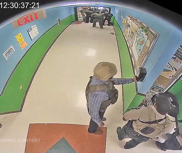 Gonzales can be seen in the video wearing a helmet and bulletproof vest over his checkered shirt and then taking a squirt of hand sanitizer from a wall mounted dispenser and rubbing it on his hands